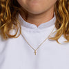 Halsband med kors i guld på tjej klädd för konfirmation