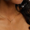 Halsband dam, kors i äkta guld på en kvinnas hals